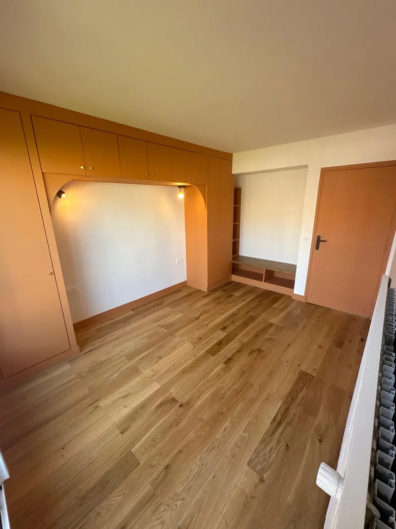 Chambre rénovée par Renovaurea avec une alcôve sur mesure éclairée et une peinture terracotta