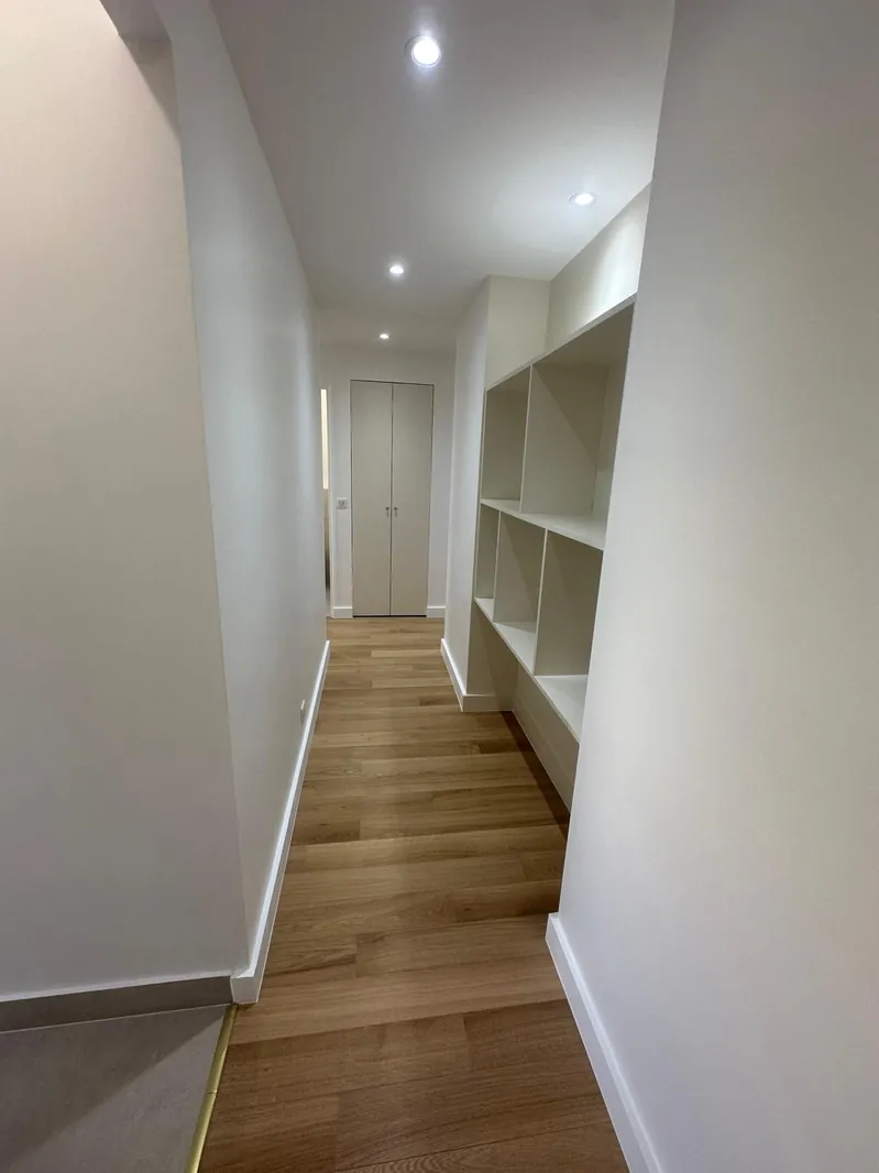 Couloir rénové par Renovaurea avec une bibliothèque sur mesure à niches intégrée dans le mur