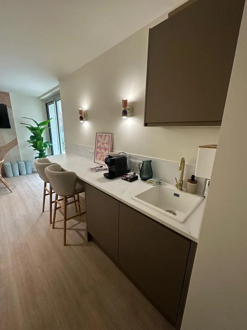 Cuisine ouverte sur le séjour rénovée par Renovaurea, avec comptoir bar et hotte encastrée sur mesure